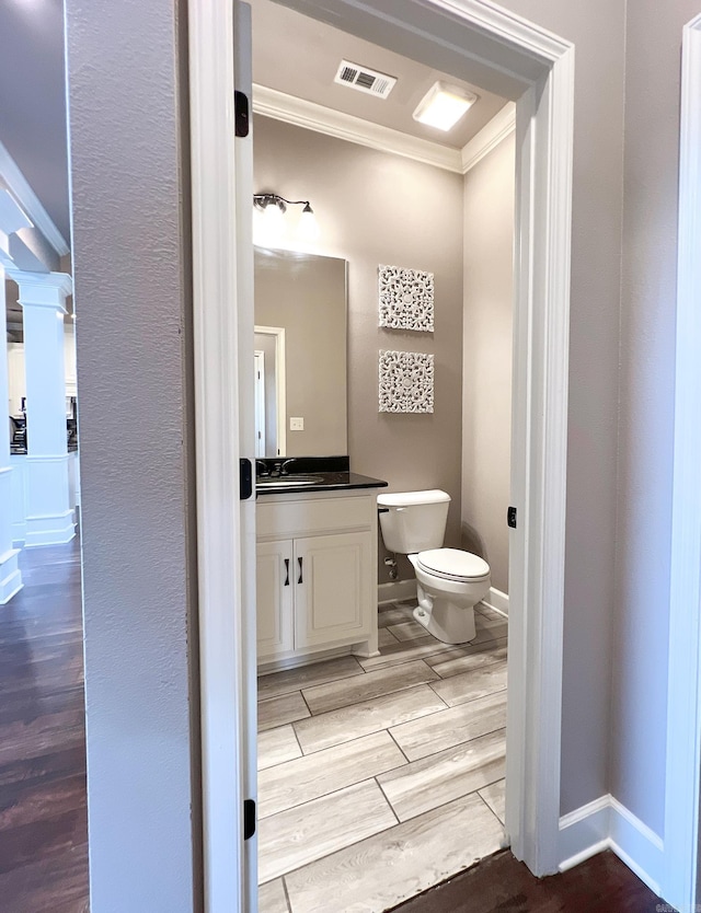 bathroom featuring vanity, hardwood / wood-style flooring, and toilet