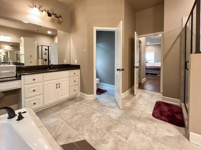 bathroom with wood-type flooring, vanity, toilet, and walk in shower