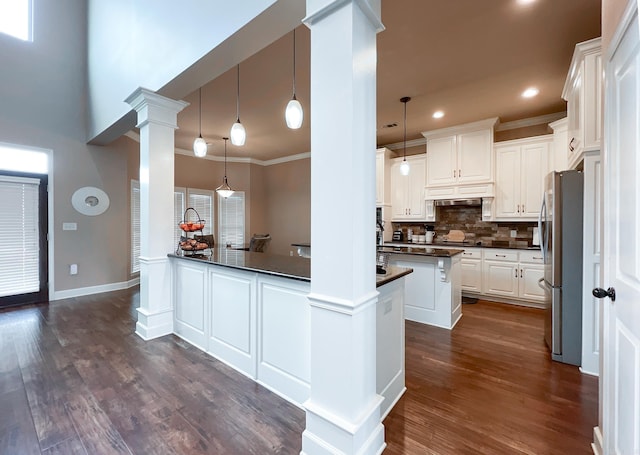 kitchen featuring kitchen peninsula, white cabinetry, hanging light fixtures, and dark hardwood / wood-style floors