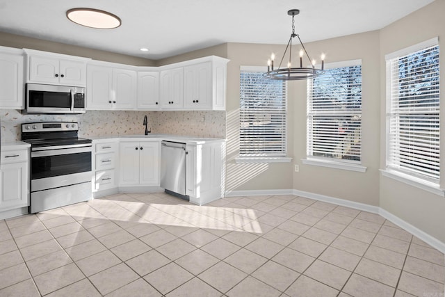 kitchen with white cabinets, light tile patterned floors, and appliances with stainless steel finishes