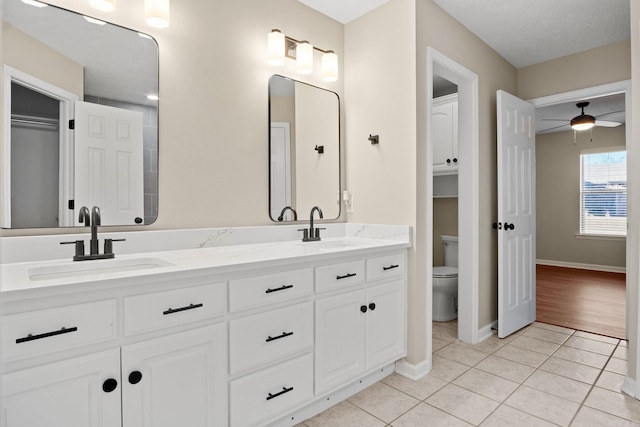 bathroom featuring vanity, tile patterned floors, ceiling fan, toilet, and a textured ceiling