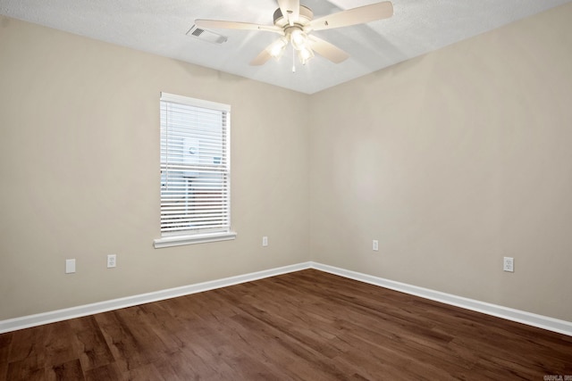 empty room featuring a textured ceiling, ceiling fan, and dark wood-type flooring