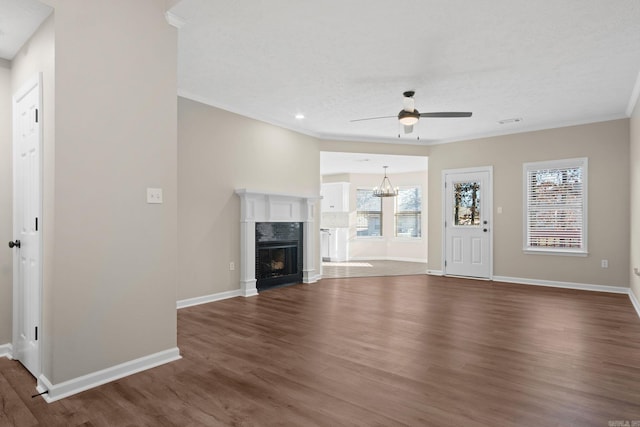 unfurnished living room featuring ceiling fan with notable chandelier, dark wood-type flooring, and a high end fireplace