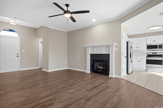 unfurnished living room with a fireplace, light hardwood / wood-style floors, ceiling fan, and ornamental molding