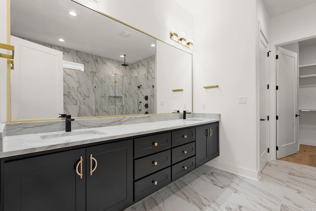 bathroom with double vanity, marble finish floor, a sink, and recessed lighting