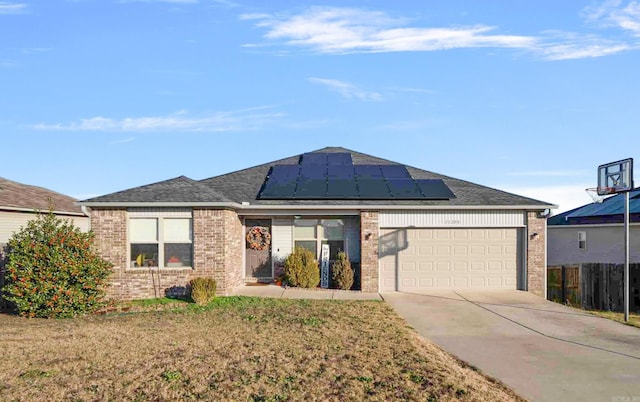 ranch-style house with solar panels, a garage, and a front lawn