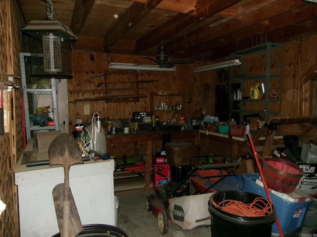 garage with a workshop area, ceiling fan, and wood walls