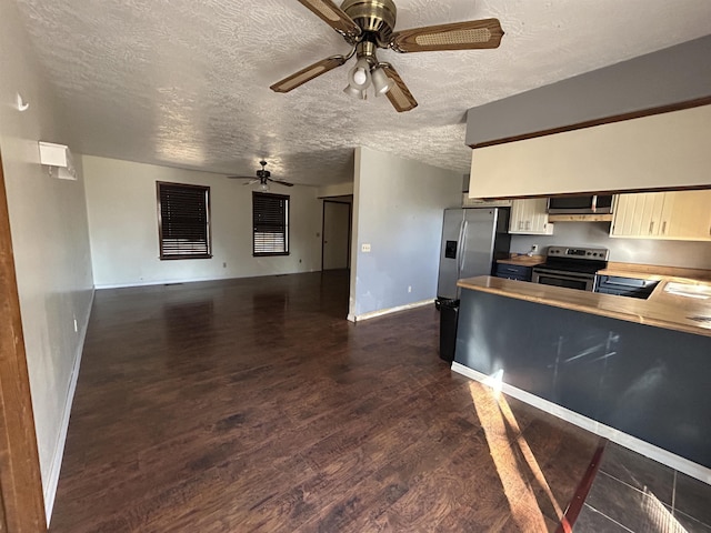 kitchen featuring appliances with stainless steel finishes, a textured ceiling, and dark hardwood / wood-style flooring