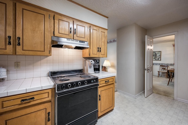 kitchen featuring a textured ceiling, tasteful backsplash, tile counters, and black / electric stove