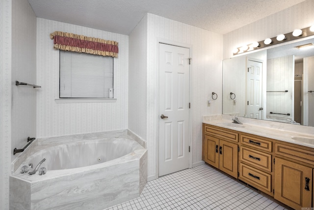 bathroom featuring tile patterned flooring, a bathtub, a textured ceiling, and vanity