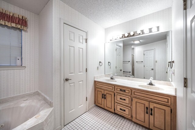 bathroom with a washtub, vanity, and a textured ceiling