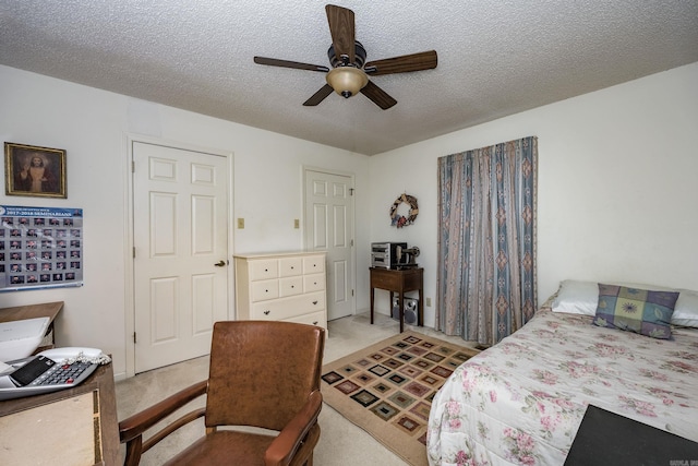 carpeted bedroom featuring a textured ceiling and ceiling fan