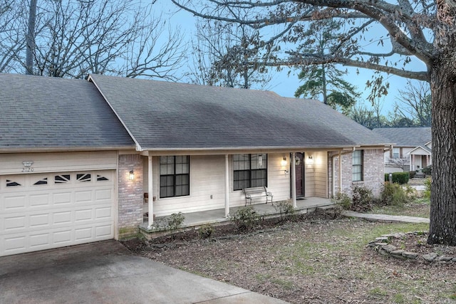 ranch-style house featuring covered porch and a garage