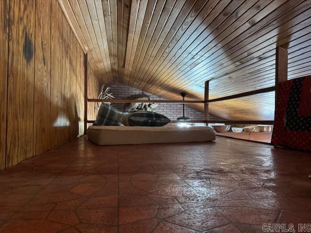 additional living space with lofted ceiling, wooden ceiling, and wood walls