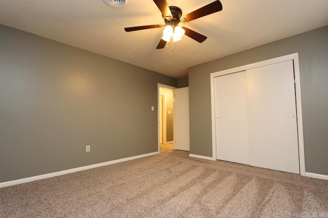 unfurnished bedroom with ceiling fan, carpet floors, and a closet