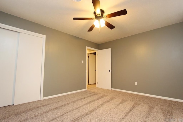 unfurnished bedroom with ceiling fan, a closet, and carpet