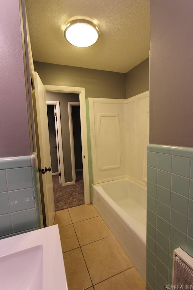 bathroom with tile patterned floors, radiator, a textured ceiling, and shower with separate bathtub