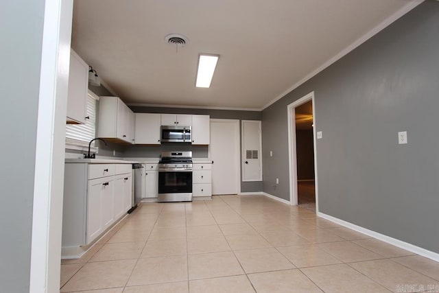 kitchen with white cabinetry, sink, stainless steel appliances, crown molding, and light tile patterned floors