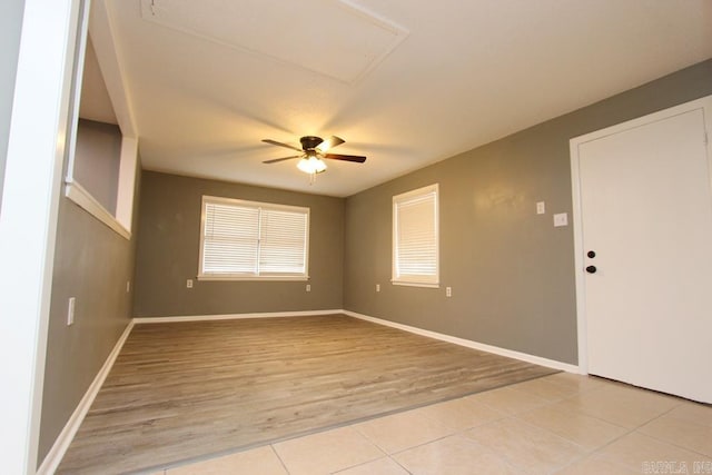 tiled spare room featuring ceiling fan