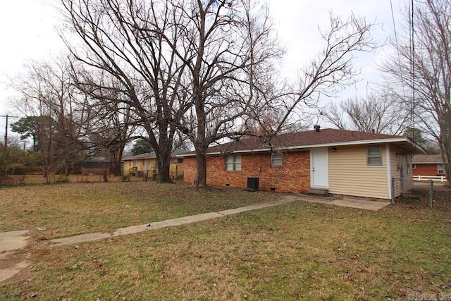 back of property with cooling unit and a lawn