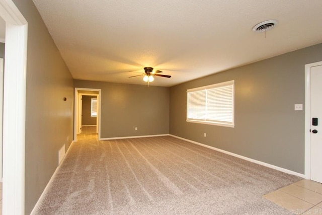 empty room with ceiling fan and light carpet