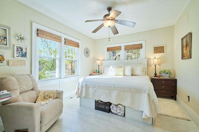 bedroom with ceiling fan, light hardwood / wood-style floors, and ornamental molding