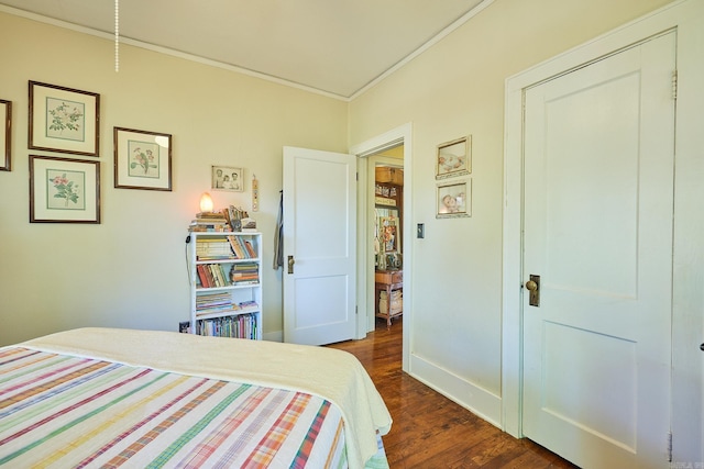 bedroom featuring crown molding and dark wood-type flooring