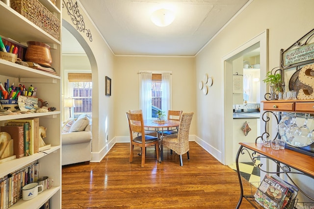 dining room with dark hardwood / wood-style flooring and crown molding