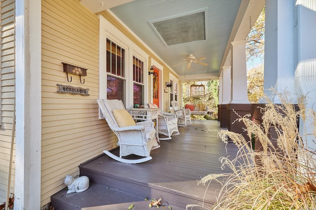 wooden terrace featuring covered porch and ceiling fan