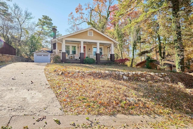 view of front of property featuring covered porch, an outdoor structure, and a garage