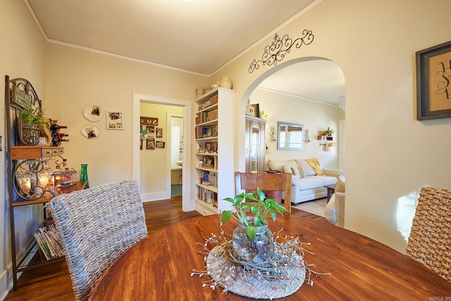 dining space with dark hardwood / wood-style flooring and crown molding