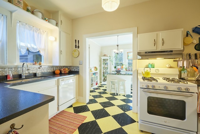 kitchen with pendant lighting, white appliances, an inviting chandelier, white cabinets, and sink