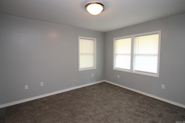 unfurnished room featuring dark carpet