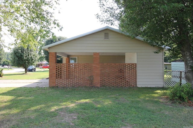 view of side of property featuring covered porch and a yard