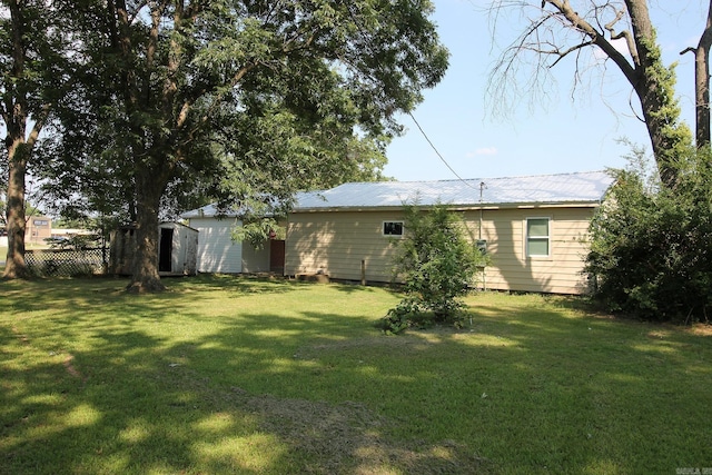 back of property with a lawn and a shed