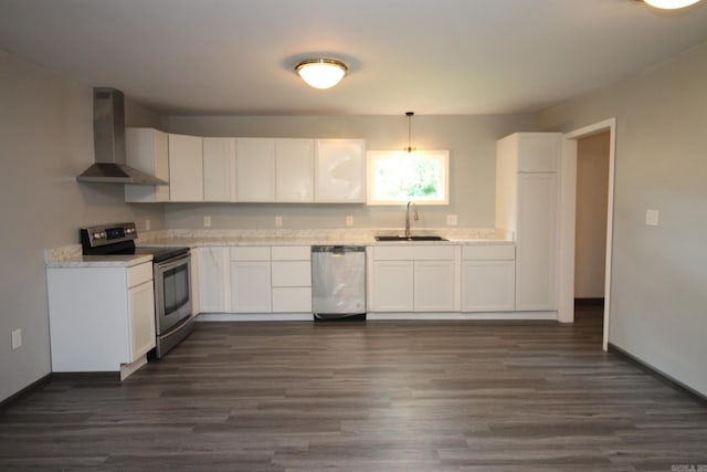 kitchen featuring white cabinets, sink, wall chimney exhaust hood, appliances with stainless steel finishes, and decorative light fixtures