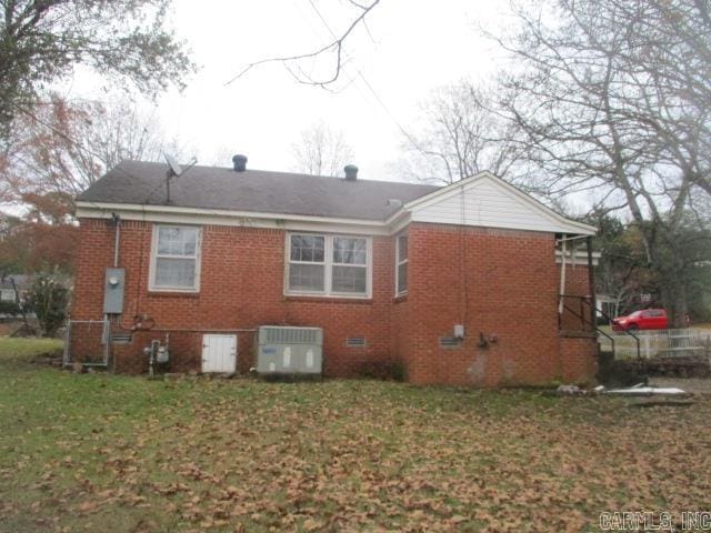 back of house with a lawn and central AC