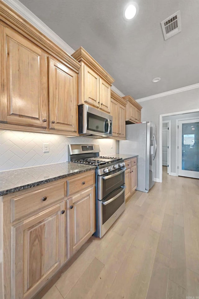 kitchen with appliances with stainless steel finishes, tasteful backsplash, ornamental molding, light brown cabinets, and dark stone countertops