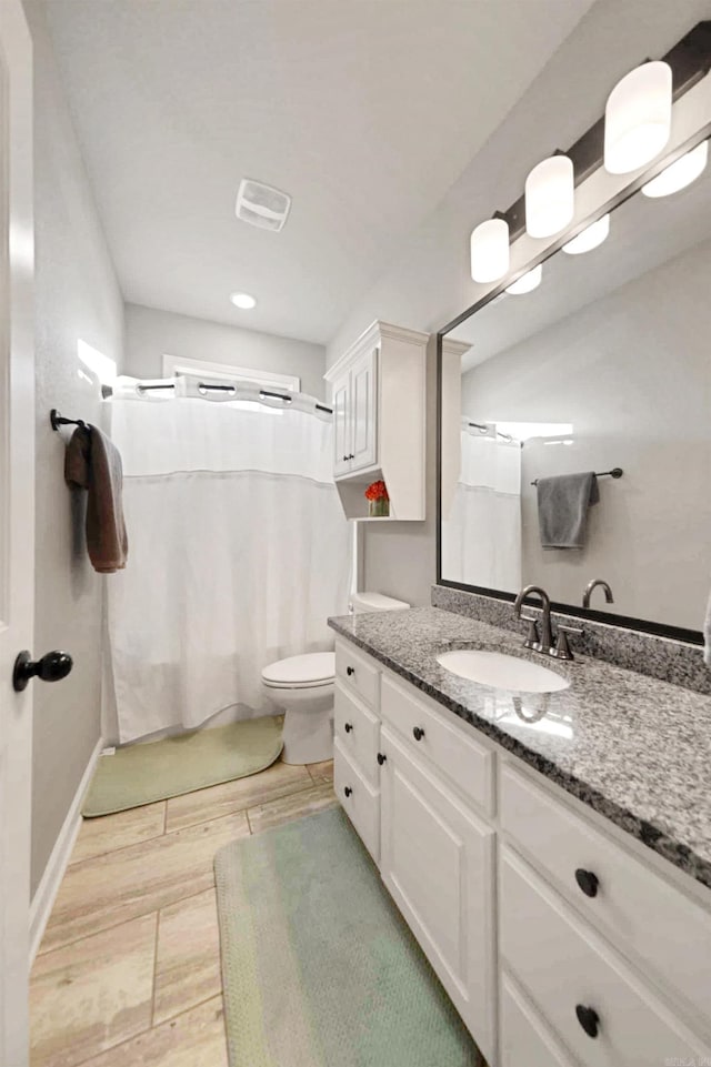 bathroom featuring vanity, curtained shower, and toilet