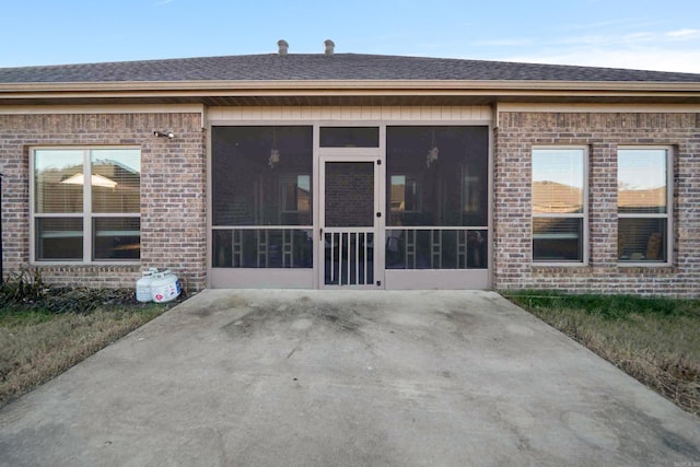 back of property with a sunroom and a patio area