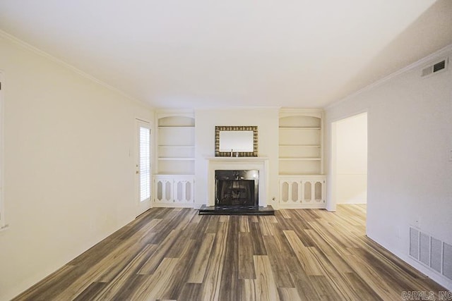 unfurnished living room featuring hardwood / wood-style floors, built in shelves, and ornamental molding