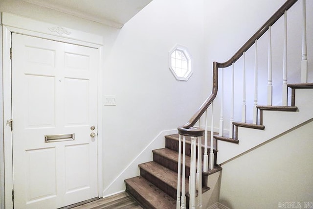 staircase with hardwood / wood-style flooring and crown molding