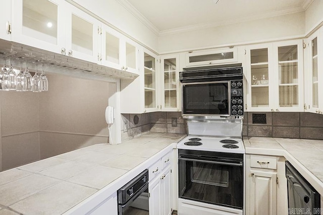 kitchen with black appliances, tile counters, white cabinetry, and backsplash