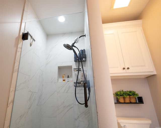 bathroom with toilet and a tile shower