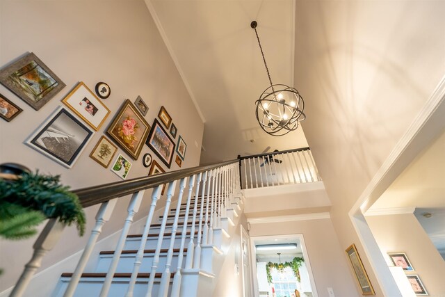 staircase featuring a towering ceiling and an inviting chandelier