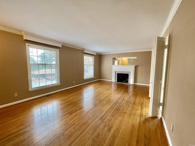 unfurnished living room with crown molding and hardwood / wood-style flooring