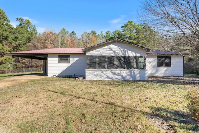 back of house with a carport and a yard