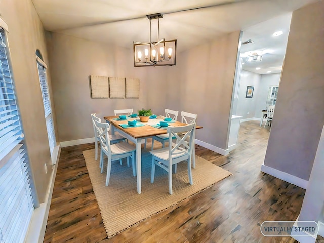 dining room with dark hardwood / wood-style floors and a notable chandelier