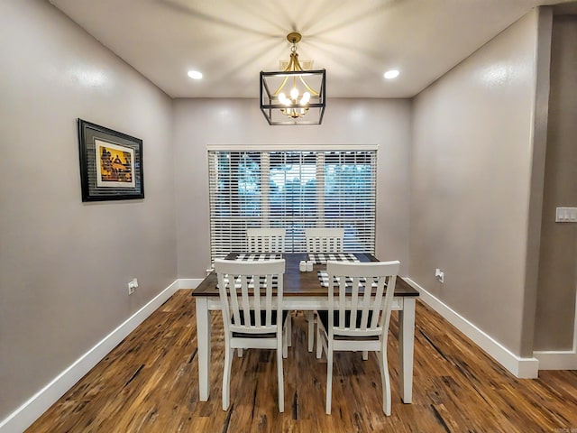 dining space with dark hardwood / wood-style floors and a notable chandelier