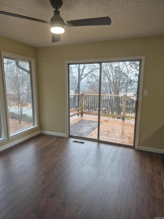 unfurnished room with ceiling fan, dark hardwood / wood-style flooring, and a textured ceiling